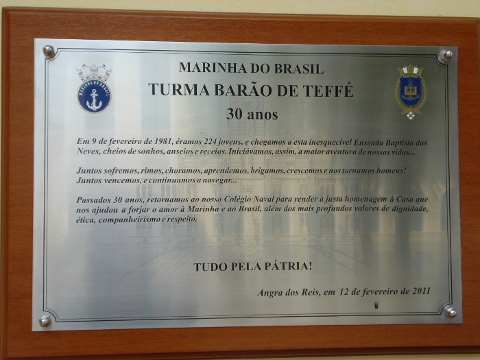 Placa comemorativa dos 30 anos da Turma Barão de Teffé, em metal escovado sobre moldura de madeira, com os emblemas da Marinha e do Colégio Naval e a inscrição de homenagem